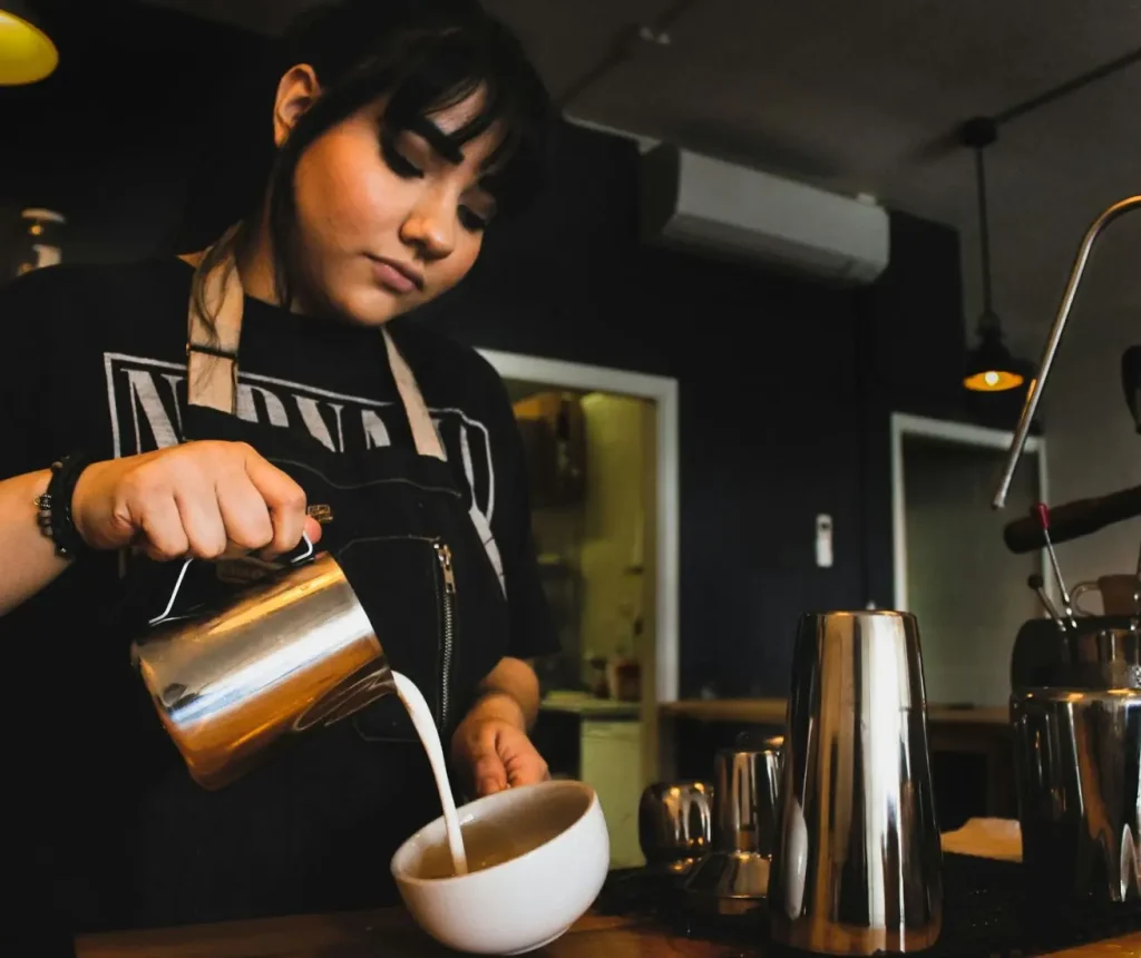 Barista pouring coffee at a small café