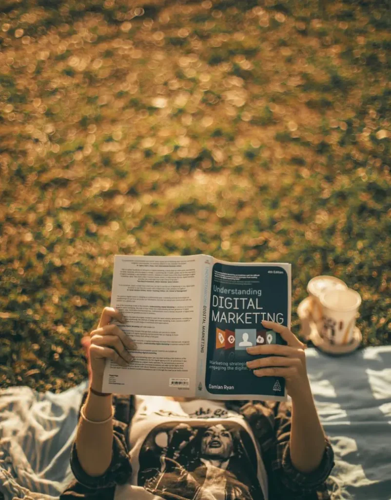 Person reading a book about digital marketing, symbolising learning and guidance for small business growth